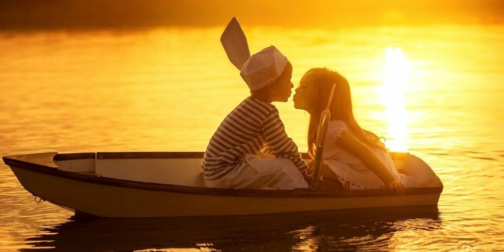 children_friends_kiss_in_boat-wide